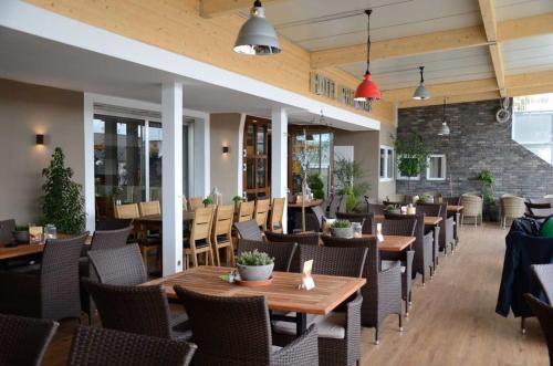 吕德斯海姆莱因斯坦酒店的配有木桌和椅子的餐厅