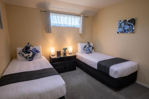 基督城阿贝拉洛奇尔舒汽车旅馆的配有两盏灯和一扇窗户的客房内的两张床