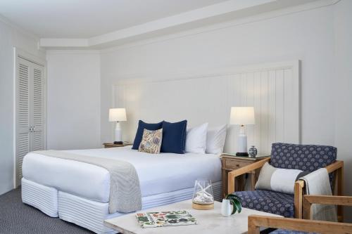 尼尔森湾安克雷奇斯蒂芬斯港酒店的一间卧室配有一张大床和一把椅子