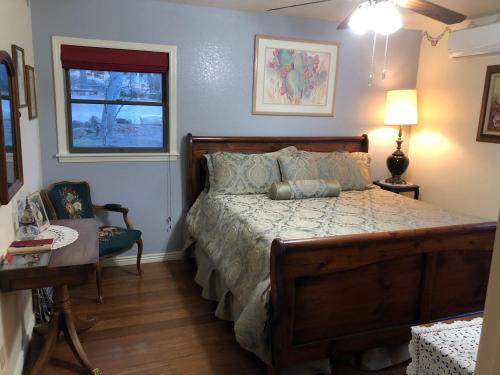 NicksvilleRamsey Canyon B&B的一间卧室配有一张床、一张桌子和一个窗户。