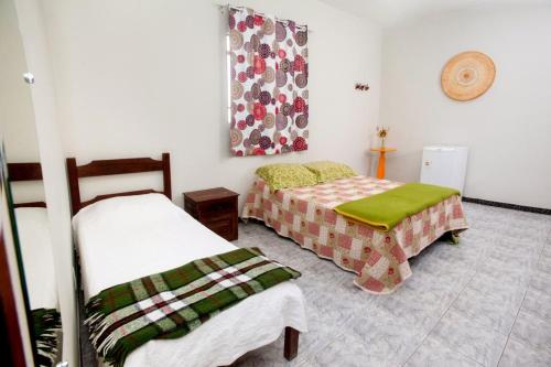 迪亚曼蒂纳Pousada Casa da Cintia的一间客房内配有两张床的房间