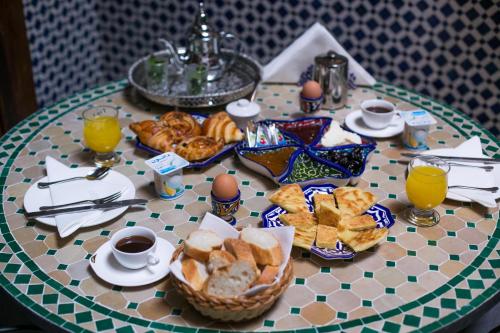 梅克内斯Dar Meknes Tresor的餐桌,早餐包括面包和橙汁