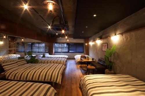 名古屋Guest House Re-worth Yabacho1 1F的一间设有四张床和一张桌子的房间