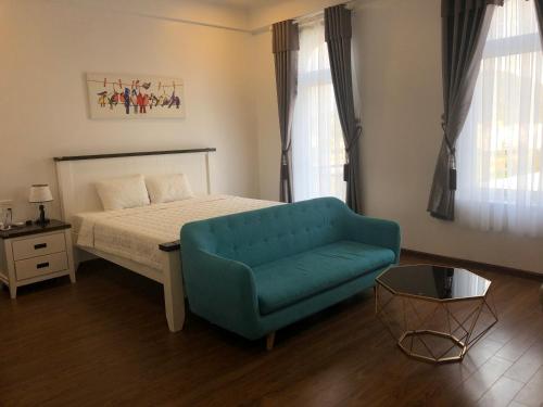 Ðưc TrọngNgoc Lan Hotel and Coffee的一间卧室配有一张床和一张蓝色的沙发