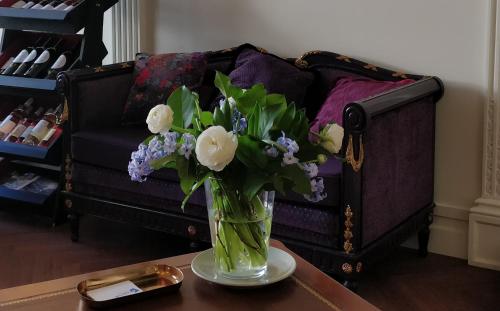 波尔多Hotel Bleu de Mer的沙发前桌子上的花瓶