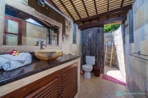 BanjarVilla Segara Murti - Stylish Beachfront Villa!的一间带水槽和卫生间的浴室