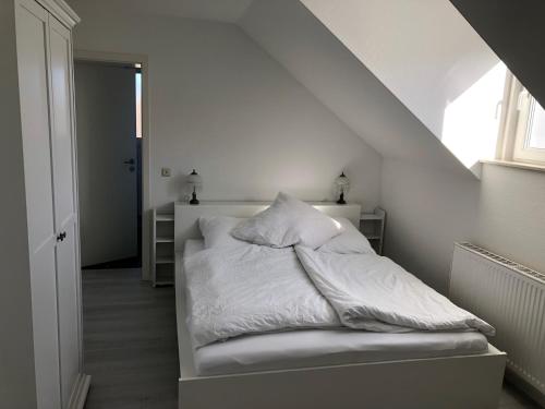 巴特明斯特艾弗尔eifelTIME - Ferienwohnung的一张带白色床单和枕头的床