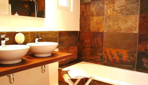 弗鲁瓦德泰尔萨瓦勒酒店的浴室配有两个盥洗盆和浴缸。