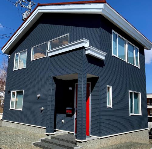 富良野Hakobune Furano的蓝色的房子,有红色的门