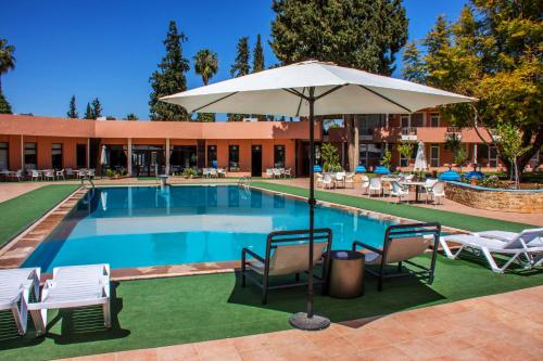 贝尼迈拉勒贝尼迈拉勒橄榄树瀑布酒店的一个带椅子和遮阳伞的游泳池