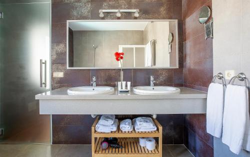 科斯塔特吉塞卡勒塔斯村庄旅馆的浴室设有2个水槽、镜子和毛巾。