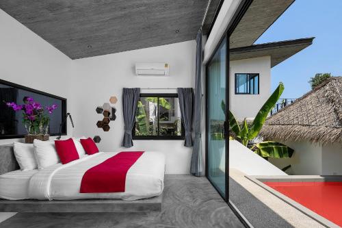 涛岛Pahili Pool Villas - SHA Plus的一间卧室配有一张带红色枕头的大床