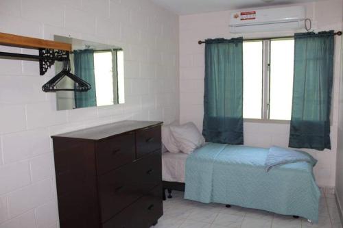 阿皮亚Lotopa Home的一间卧室配有一张床、梳妆台和镜子