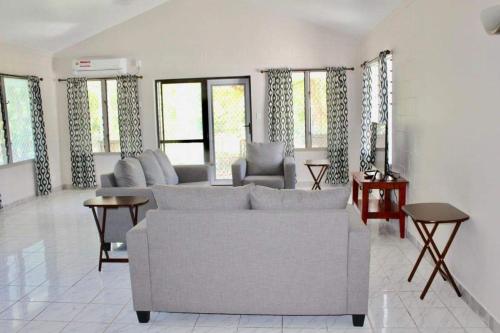 阿皮亚Lotopa Home的带沙发、椅子和窗户的客厅