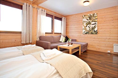 特隆赫姆Sandmoen Bed & Breakfast, Free Parking的一间带两张床和一张沙发的客厅
