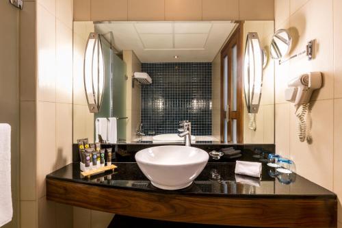 迪拜Novotel Deira Creekside Dubai的一间带水槽和大镜子的浴室