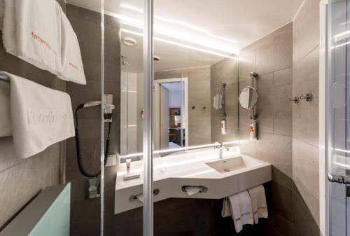 马格德堡马格德堡城际酒店的一间带水槽和镜子的浴室