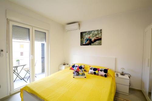 乌马格La Piazza的一间卧室,卧室内设有一张黄色的大床