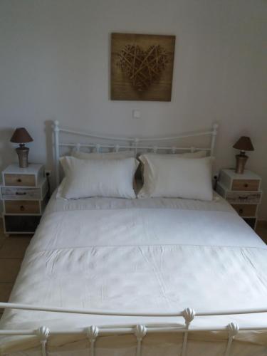 卡尔扎迈纳Ellie's的卧室内的一张带白色床单和枕头的床