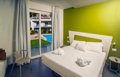 阿茨特雷扎Ciclope Resort的卧室配有白色的床和绿色的墙壁