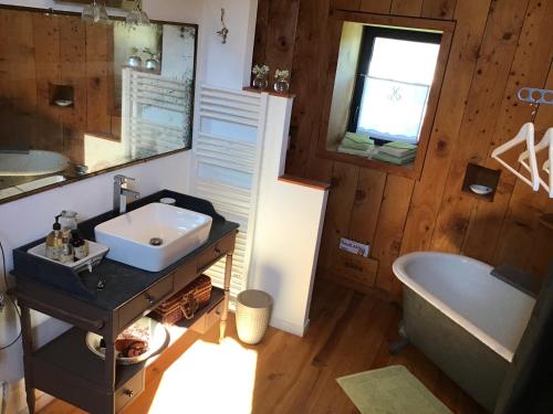 马尔戈红磨坊德玛歌度假屋的浴室配有盥洗盆和浴缸。