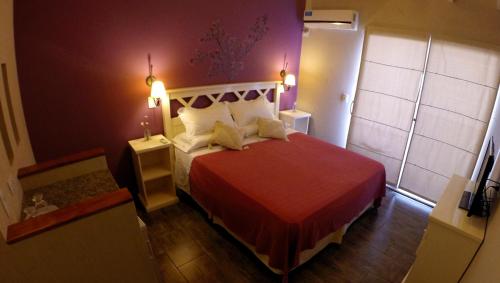 格塞尔镇Hostería Magnolia的一间卧室配有一张红色床罩的床