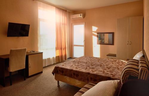 阿德勒Hotel Margo的配有一张床和一张书桌的酒店客房