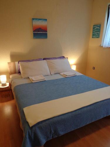 普莱曼图拉Guesthouse Aotearoa Premantura的一间卧室配有一张大床和两条毛巾