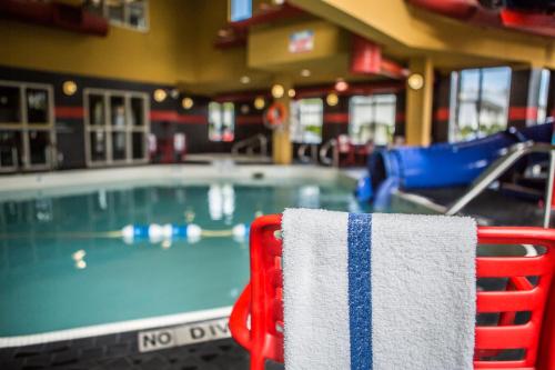 基洛纳基洛纳舒适套房酒店的游泳池旁椅子上的红白毛巾
