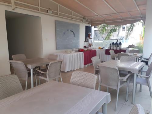 卡塔赫纳明塔克酒店及酒廊的一家餐厅,有桌椅,有一位女性背景