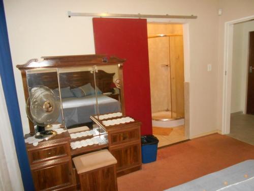 肯普顿帕克Pilot Inn Accommodation的一间卧室配有一张床和一个带镜子的梳妆台