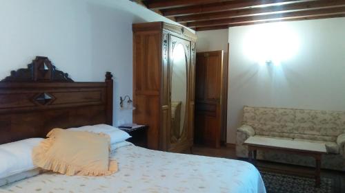 Villanueva de la PeñaPosada Santa Eulalia的一间卧室配有一张床和一张沙发