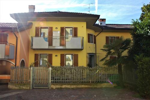 阿科ECO - Casa Vacanze Arcobaleno的前面有栅栏的黄色房子