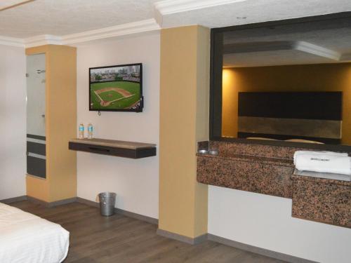 墨西哥城首尔酒店的酒店客房的墙上配有平面电视