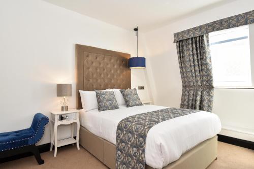 戈尔韦The Lane - Boutique Residence的一间卧室配有一张大床和一张蓝色椅子