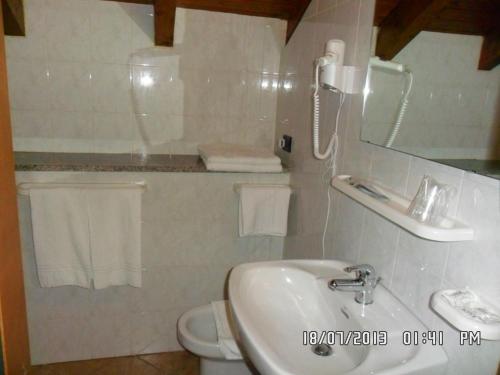 Miazzina拉坎提娜戴尔皮托钟楼酒店的一间带水槽、镜子和卫生间的浴室
