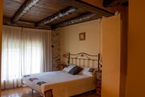 Las Cuevas de Cañart马萨达安达贝乡村民宿的一间卧室设有一张大床和一个窗户。