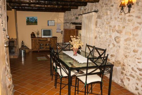 Las Cuevas de Cañart马萨达安达贝乡村民宿的一间设有玻璃桌和椅子的用餐室