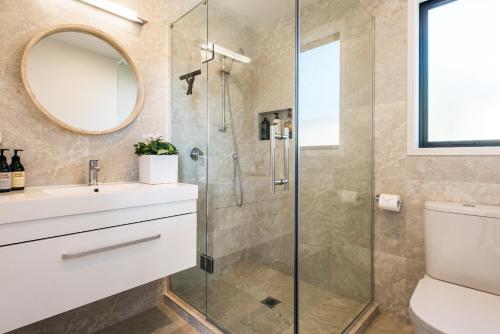 欧尼罗亚皇后街旅馆的带淋浴、盥洗盆和镜子的浴室