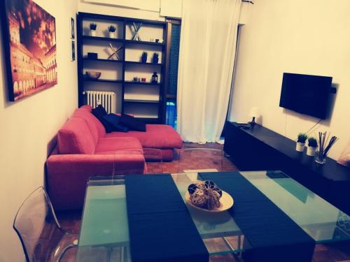 米兰Residence Vigliani的客厅配有红色的沙发和玻璃桌