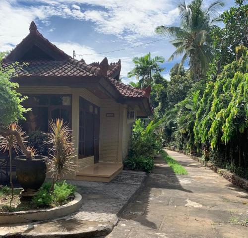 特贾库拉Bali Sea Breeze Cottage Ketut的花园中的小房子