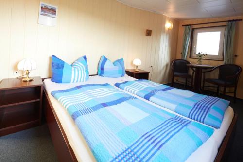 欧巴德伍斯图Hotelschiff Stinne的一间卧室配有一张带蓝色枕头的大床