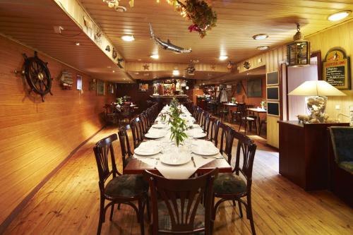 欧巴德伍斯图Hotelschiff Stinne的长长的用餐室配有长桌子和椅子
