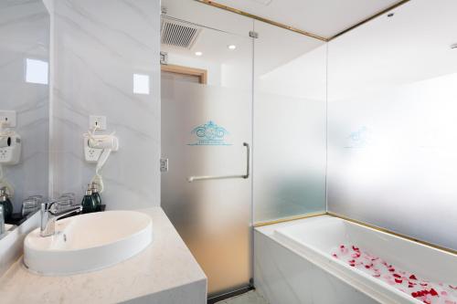 芽庄Crown Hotel Nha Trang的白色的浴室设有水槽和浴缸。