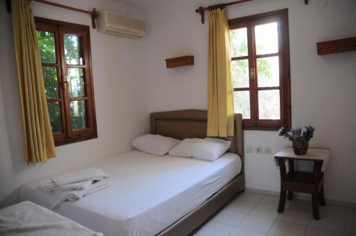 博德鲁姆古籁酒店的一间小卧室,配有床和2个窗户