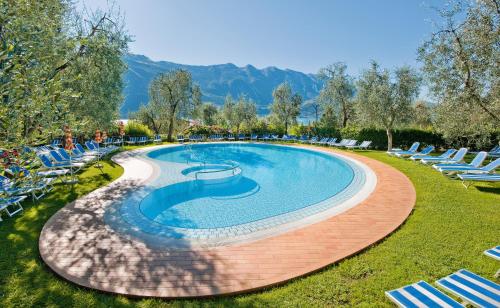 利莫内-苏尔加达理想酒店的一个带椅子的游泳池,背景是山脉