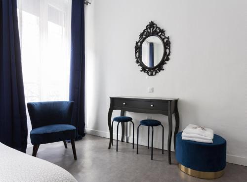 巴黎Hotel Europe BLV的一间卧室配有桌子、两把椅子和镜子