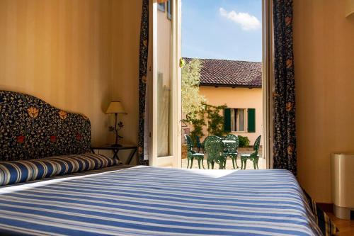 佩切图好斯蒂勒瑞杜高尔夫酒店的一间卧室配有一张床和一个带椅子的窗户。