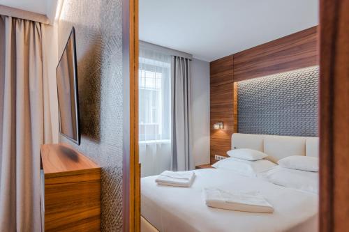 布达佩斯布达佩斯精品酒店的酒店客房,配有床和镜子
