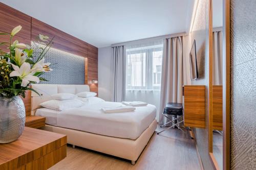 布达佩斯布达佩斯精品酒店的配有一张床和花瓶的酒店客房